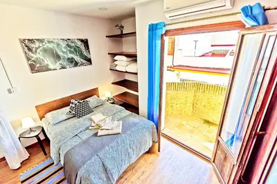 a bedroom with a bed and a sliding glass door at Plaza Noria Apartments with Balconies in El Puerto de Santa María