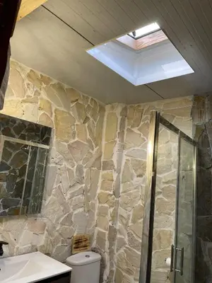 a stone bathroom with a shower and a toilet at Casa Xeneize Punta Candor in Cádiz