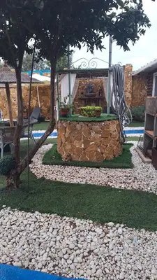 a garden with a swing and a stone wall at Casa Xeneize Punta Candor in Cádiz