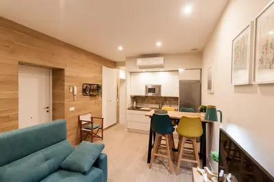a living room with a couch and a kitchen at Apartamento - Patio 1812 in Cádiz