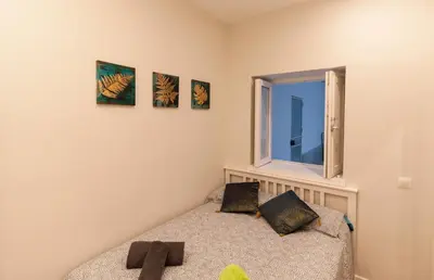 a small bedroom with a bed and a window at Apartamento - Patio 1812 in Cádiz