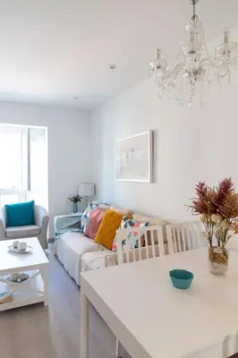 a white living room with a couch and a table at El Embrujo de La Caleta by Gades Gestión in Cádiz