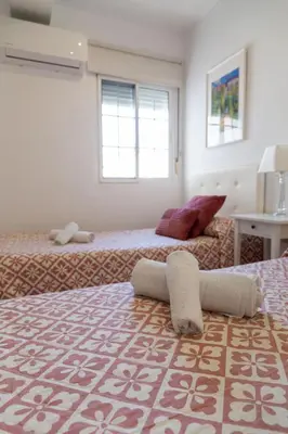 a bedroom with two beds and a window at El Embrujo de La Caleta by Gades Gestión in Cádiz