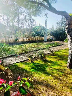 a garden with a fence and flowers in the grass at Agradable casa de campo con piscina en la Barrosa in Chiclana de la Frontera