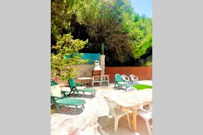 a patio with chairs and tables and a fireplace at Agradable casa de campo con piscina en la Barrosa in Chiclana de la Frontera