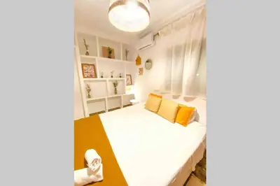 a bedroom with a white bed with orange pillows at Agradable casa de campo con piscina en la Barrosa in Chiclana de la Frontera