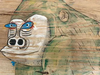 a drawing of a mask on a wooden table at Apartamentos la Selva - Rafael de la Viesca in Cádiz