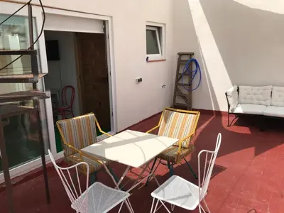a table and chairs on a balcony with a couch at Apartamentos la Selva - Rafael de la Viesca in Cádiz