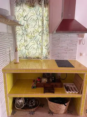 a toy kitchen with a yellow shelf and a sink at Apartamentos la Selva - Rafael de la Viesca in Cádiz