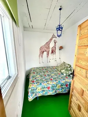 a bedroom with a bed with two giraffes on the wall at Apartamentos la Selva - Rafael de la Viesca in Cádiz