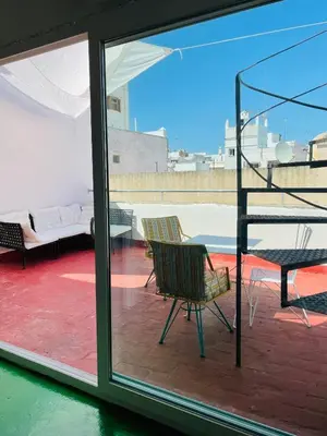 a balcony with a chair and a table and a couch at Apartamentos la Selva - Rafael de la Viesca in Cádiz