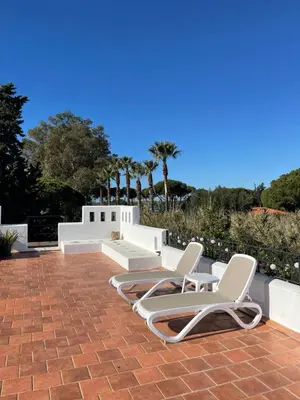 two chairs and a bench on a brick patio at Studio La Maravilla 1001 Nacht, Playa La Barrosa in Chiclana de la Frontera
