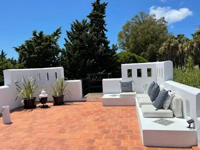 a patio with white couches sitting on a brick floor at Studio La Maravilla 1001 Nacht, Playa La Barrosa in Chiclana de la Frontera