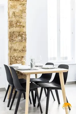 a dining room table with chairs and glasses on it at El Arco del Fotografo by Cadiz Time in Cádiz