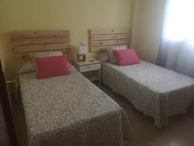 a bedroom with two beds with pink pillows at Piso con parking en el edificio, Rio san pedro, CADIZ in El Trocadero