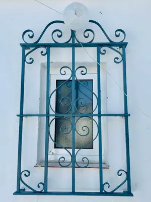a glass window on a building with a blue frame at Ático Plaza España in Jerez de la Frontera