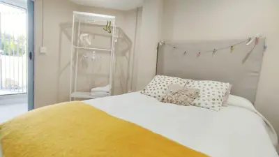 a bedroom with a white bed with a yellow blanket at Ático Plaza España in Jerez de la Frontera