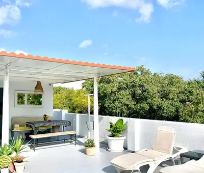 a patio with a table and chairs and a white fence at Ático Plaza España in Jerez de la Frontera