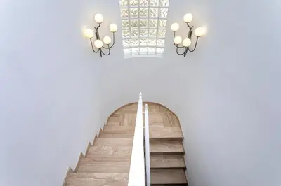 a staircase in a building with two chandeliers at Genteel Home Mirador de La Barrosa in Chiclana de la Frontera