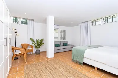 a bedroom with a bed and a couch at Genteel Home Mirador de La Barrosa in Chiclana de la Frontera