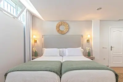a large white bed in a room with a window at Genteel Home Mirador de La Barrosa in Chiclana de la Frontera