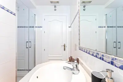 a white bathroom with a sink and a mirror at Genteel Home Mirador de La Barrosa in Chiclana de la Frontera