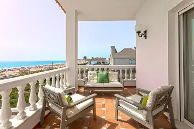 a balcony with chairs and a view of the ocean at Genteel Home Mirador de La Barrosa in Chiclana de la Frontera