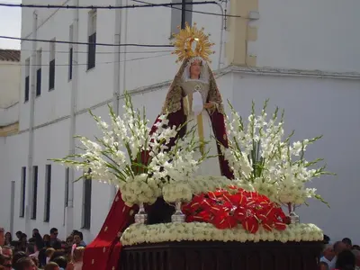 a statue of a pope on a altar with flowers at Casa Petra in Arcos de la Frontera