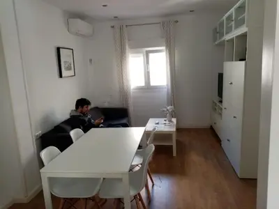 a man sitting on a couch in a living room at Paseo marítimo de Cádiz in Cádiz