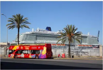 a red double decker bus in front of a cruise ship at Paseo marítimo de Cádiz in Cádiz