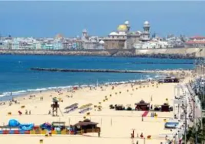 a beach with a group of people on the sand at Paseo marítimo de Cádiz in Cádiz