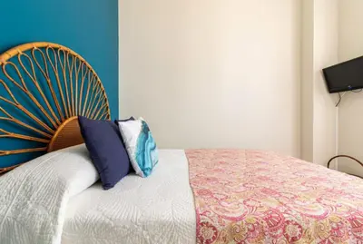 a bedroom with a bed with a wooden headboard at Sherryflat Corredera Terrace in Jerez de la Frontera