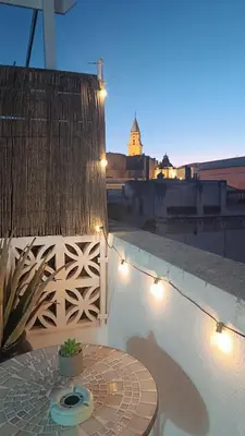 a table on the side of a balcony with lights at Sherryflat Corredera Terrace in Jerez de la Frontera