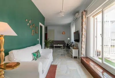 a living room with a white couch and a green wall at Sherryflat Corredera Terrace in Jerez de la Frontera
