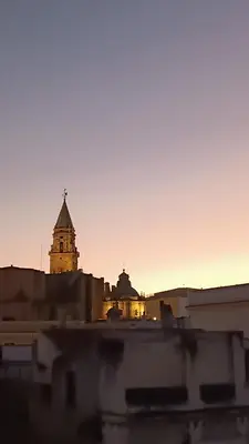 a view of a building with a clock tower at sunset at Sherryflat Corredera Terrace in Jerez de la Frontera