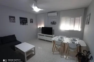 a living room with two tables and a television at Apartamento cabañiles wifi in Jerez de la Frontera