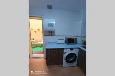 a kitchen with a washing machine and a microwave at Apartamento cabañiles wifi in Jerez de la Frontera