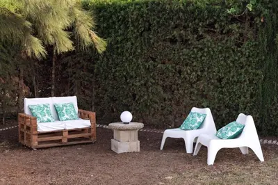 a group of chairs and a table and a tree at SOLECITO in Chiclana de la Frontera