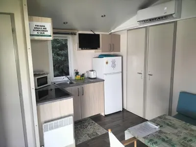 a small kitchen with a white refrigerator and a table at SOLECITO in Chiclana de la Frontera