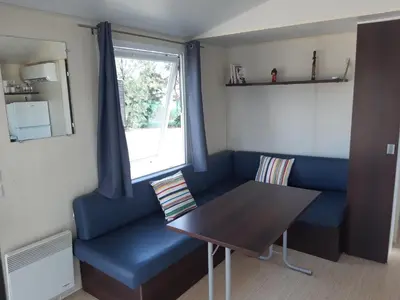 a dining room with a blue couch and a table at SOLECITO in Chiclana de la Frontera