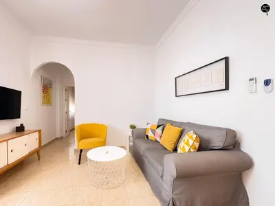 a living room with a couch and a tv at Penthouse Mara Ascensor y Playa Grupo AC Gestion in Cádiz