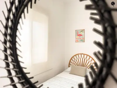 a mirror reflecting a bed in a bedroom at Penthouse Mara Ascensor y Playa Grupo AC Gestion in Cádiz