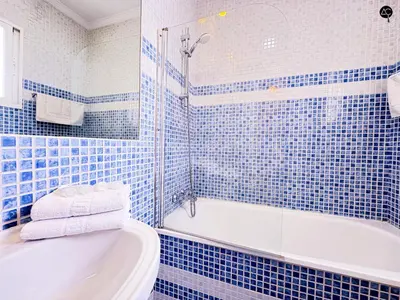 a blue tiled bathroom with a tub and a sink at Penthouse Mara Ascensor y Playa Grupo AC Gestion in Cádiz