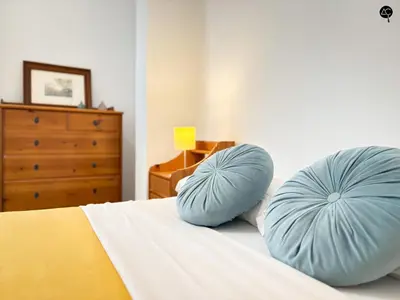 two blue pillows sitting on a bed with a dresser at Penthouse Mara Ascensor y Playa Grupo AC Gestion in Cádiz