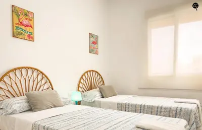 a bedroom with two beds and a window at Penthouse Mara Ascensor y Playa Grupo AC Gestion in Cádiz