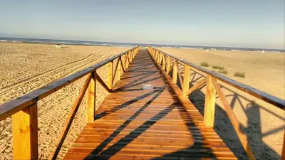 a wooden boardwalk leading down to the beach at casa lucia in Cádiz