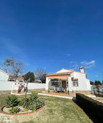 a white house with a porch and a yard at casa lucia in Cádiz