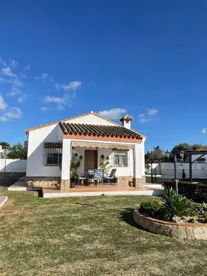 a white house with a table and chairs in a yard at casa lucia in Cádiz