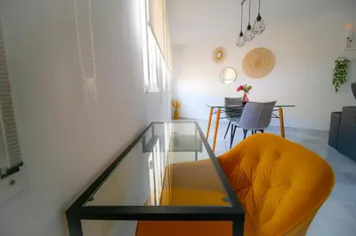 a living room with a glass table and a yellow chair at Sherryflat Atípika in Jerez de la Frontera