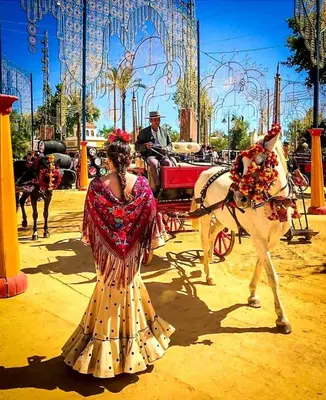 a woman in a dress standing next to a horse drawn carriage at Sherryflat Atípika in Jerez de la Frontera